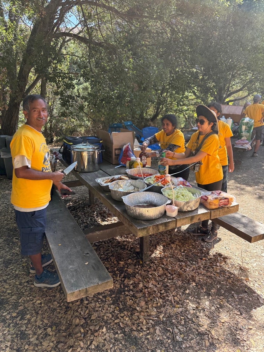 Scouts and parents preparing a meal at a campout