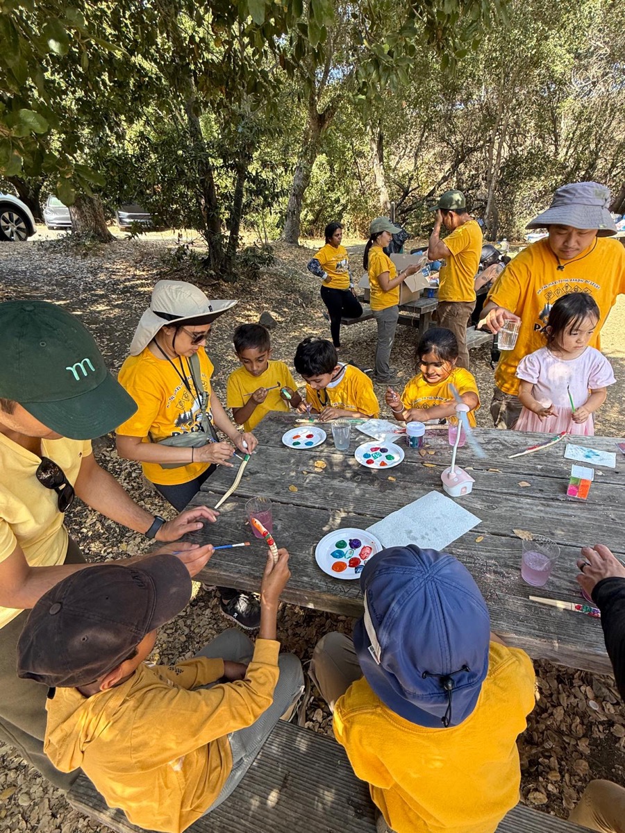 Scouts painting and doing crafts at an outdoor picnic table
