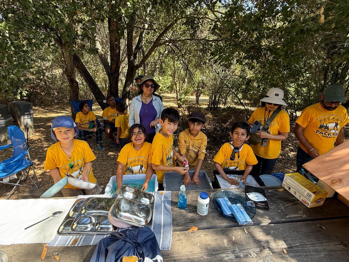 Scouts doing dishes together at a campsite