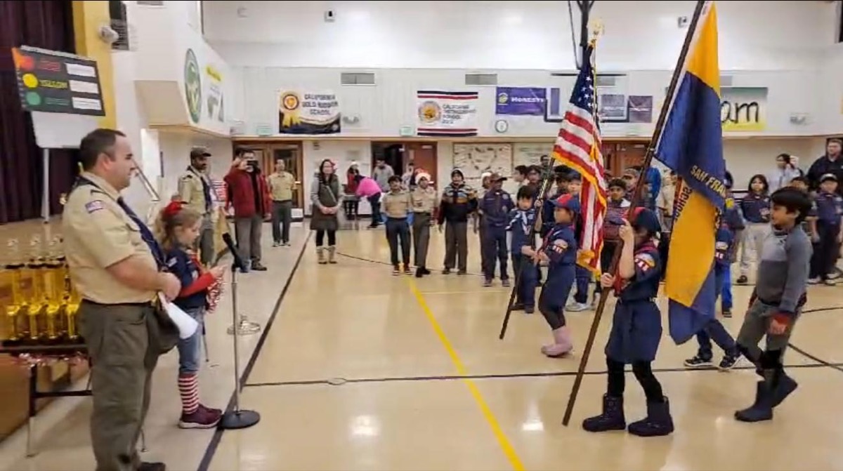 Pack 986 color guard carrying flags at a pack meeting