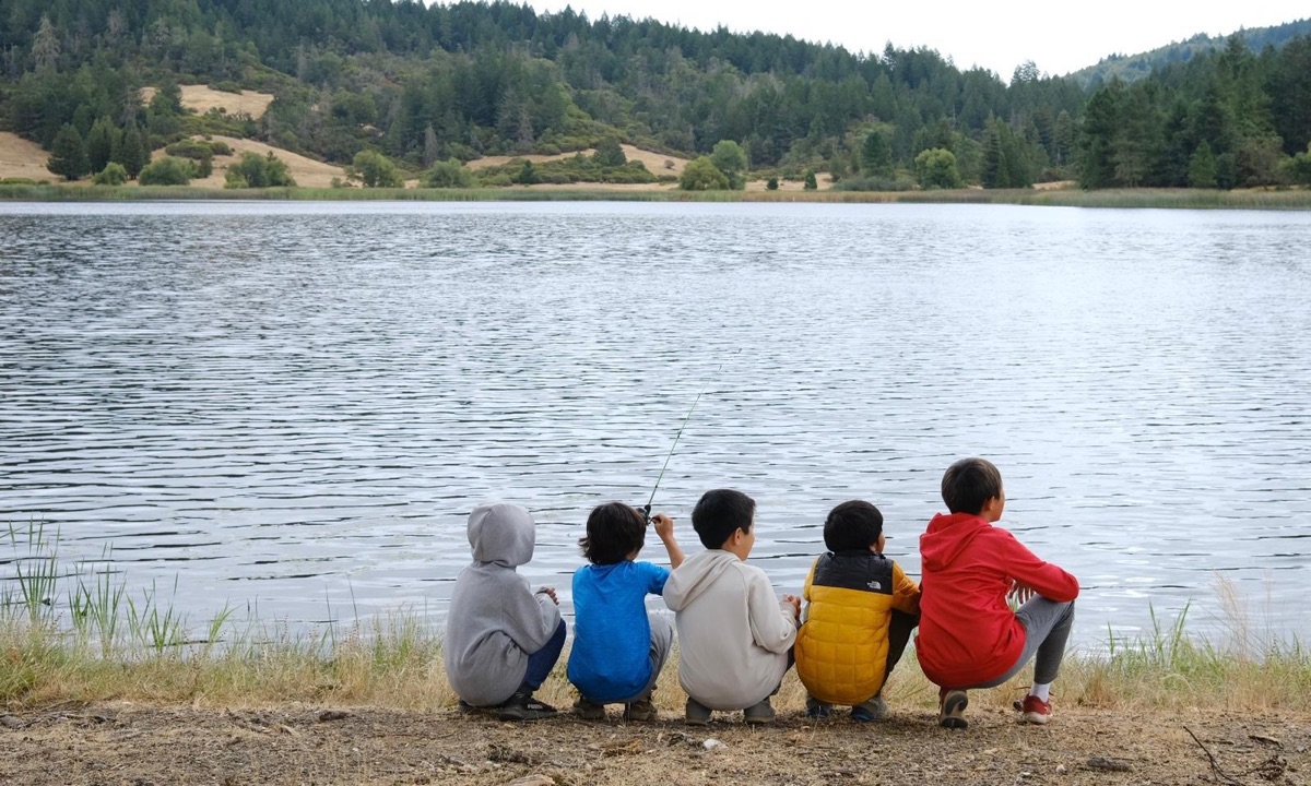 Scouts fishing at a lake on a camping trip